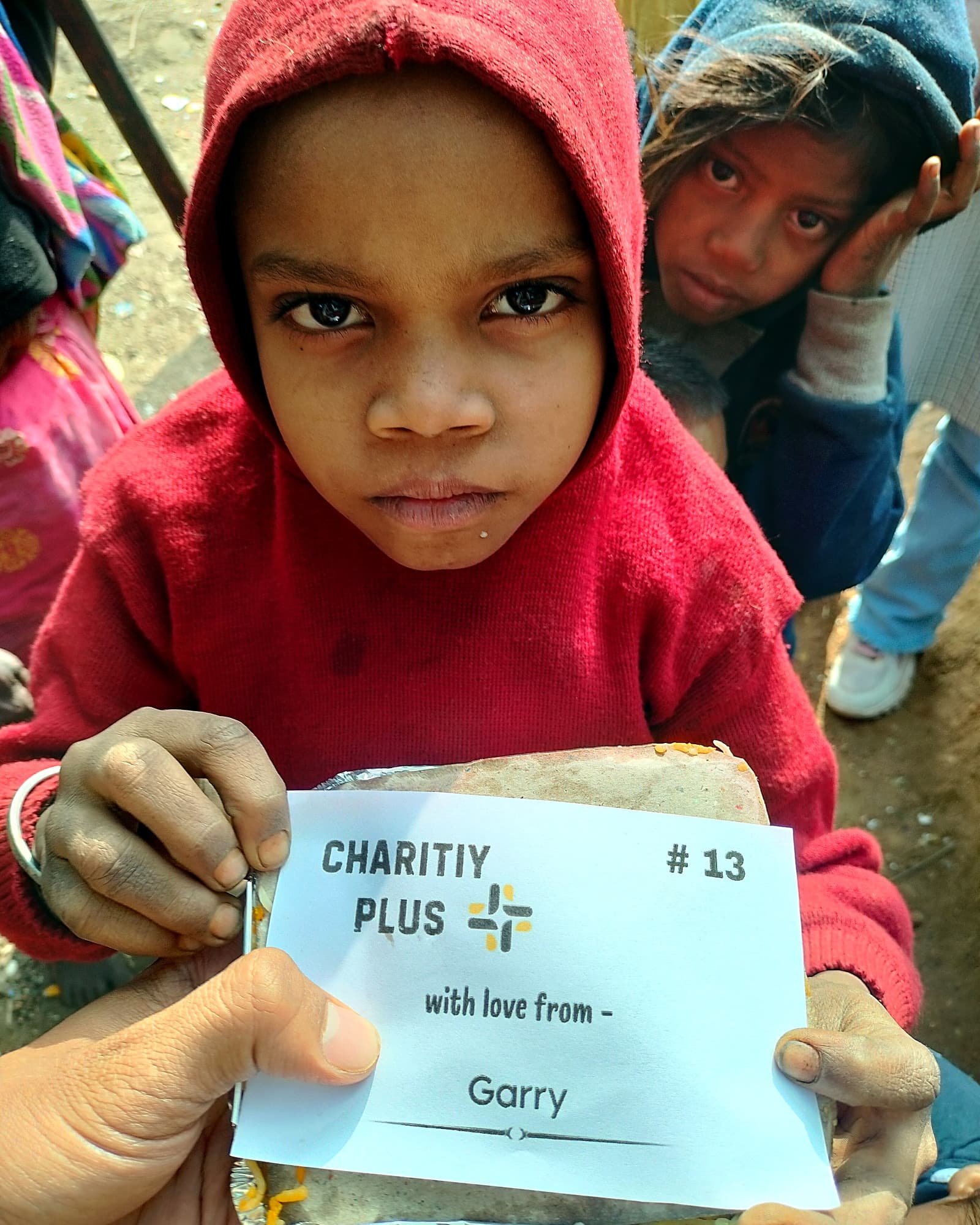 A child receives a meal packet, distribution #13
